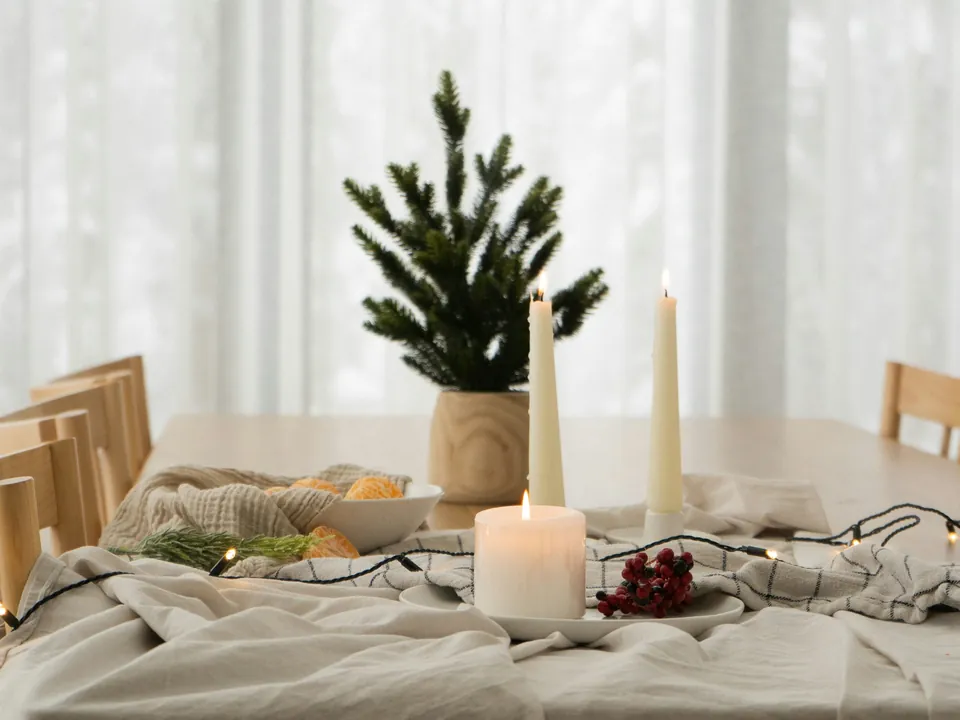 Ein Tisch mit Tännchen, Kerzen und Lichterkette